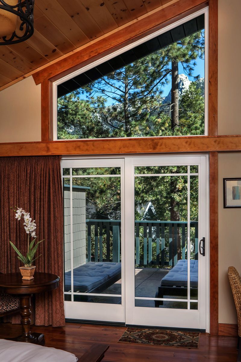 A bedroom with a sliding glass door leading to a balcony