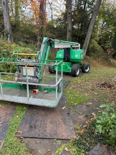 The green lift is parked in a yard next to a tree — Pittsburgh, PA — Leitzell Tree Service LLC