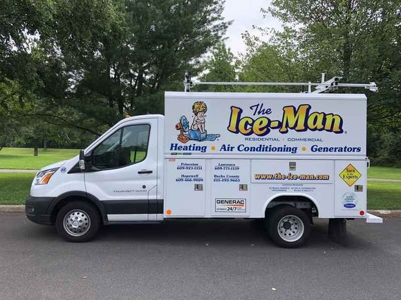 White Ice-Man HVAC service van parked on a road with trees in the background