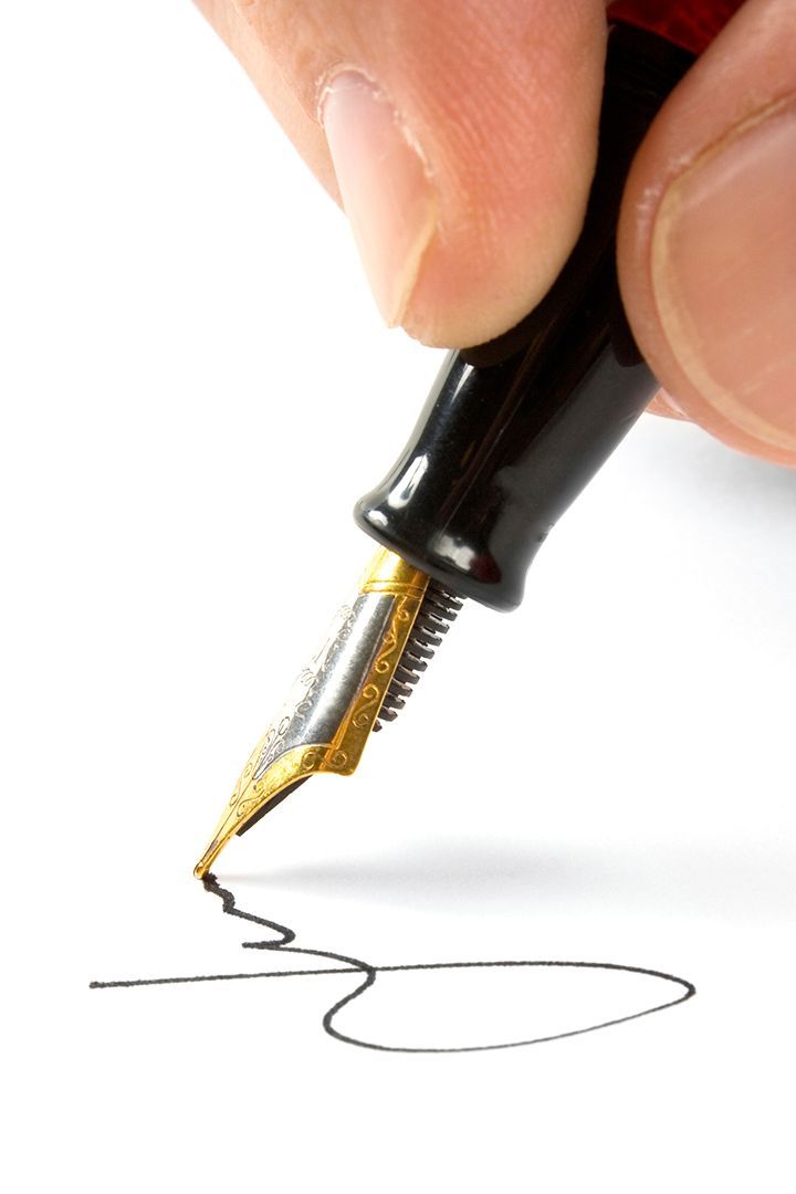 Una persona está firmando un documento con una pluma estilográfica