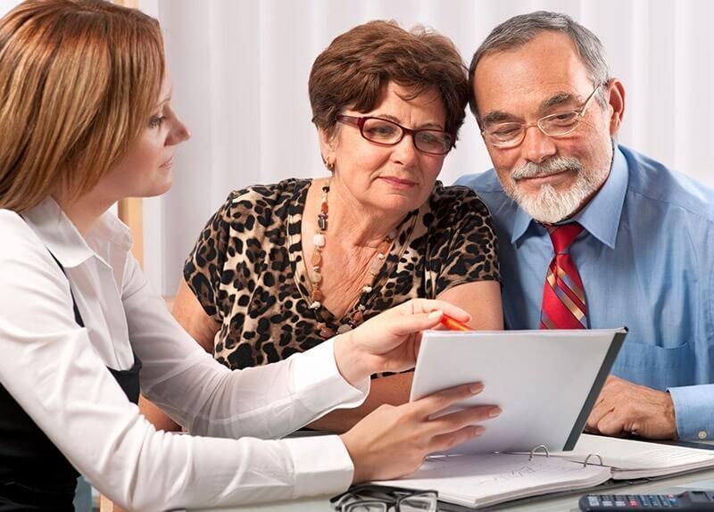 Un hombre y una mujer miran una tableta con una mujer apuntándola.