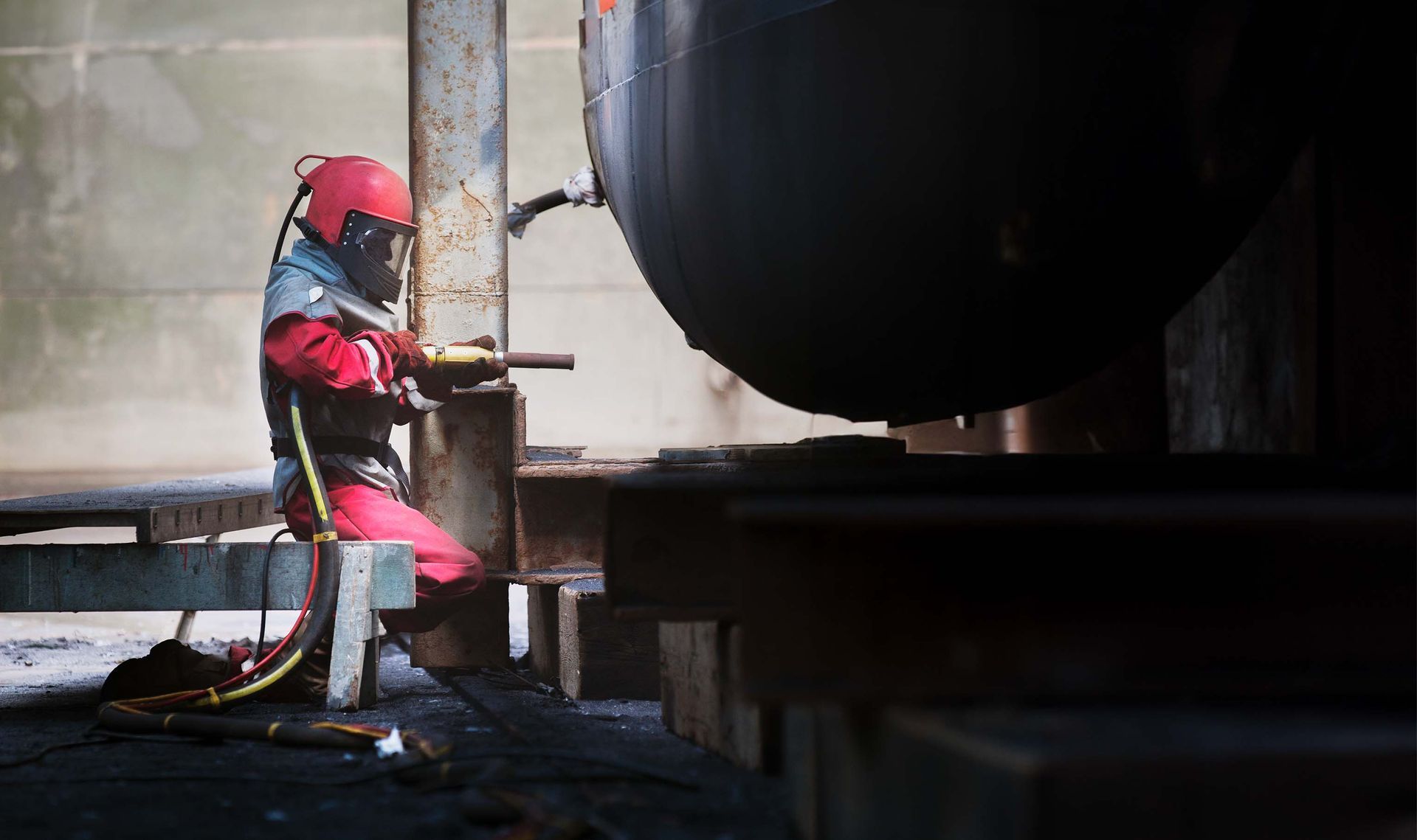 A large red ship is sitting in a dock.