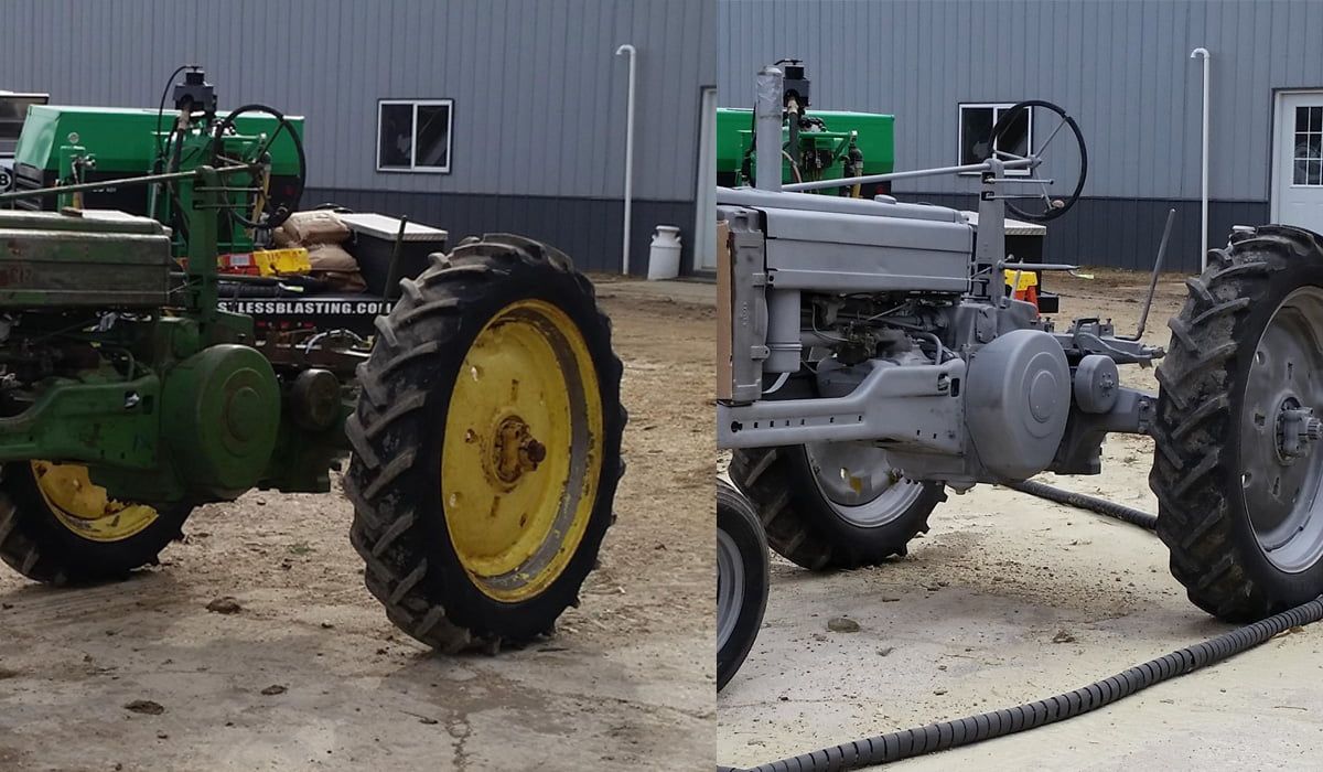 Two old tractors are parked next to each other in front of a building.