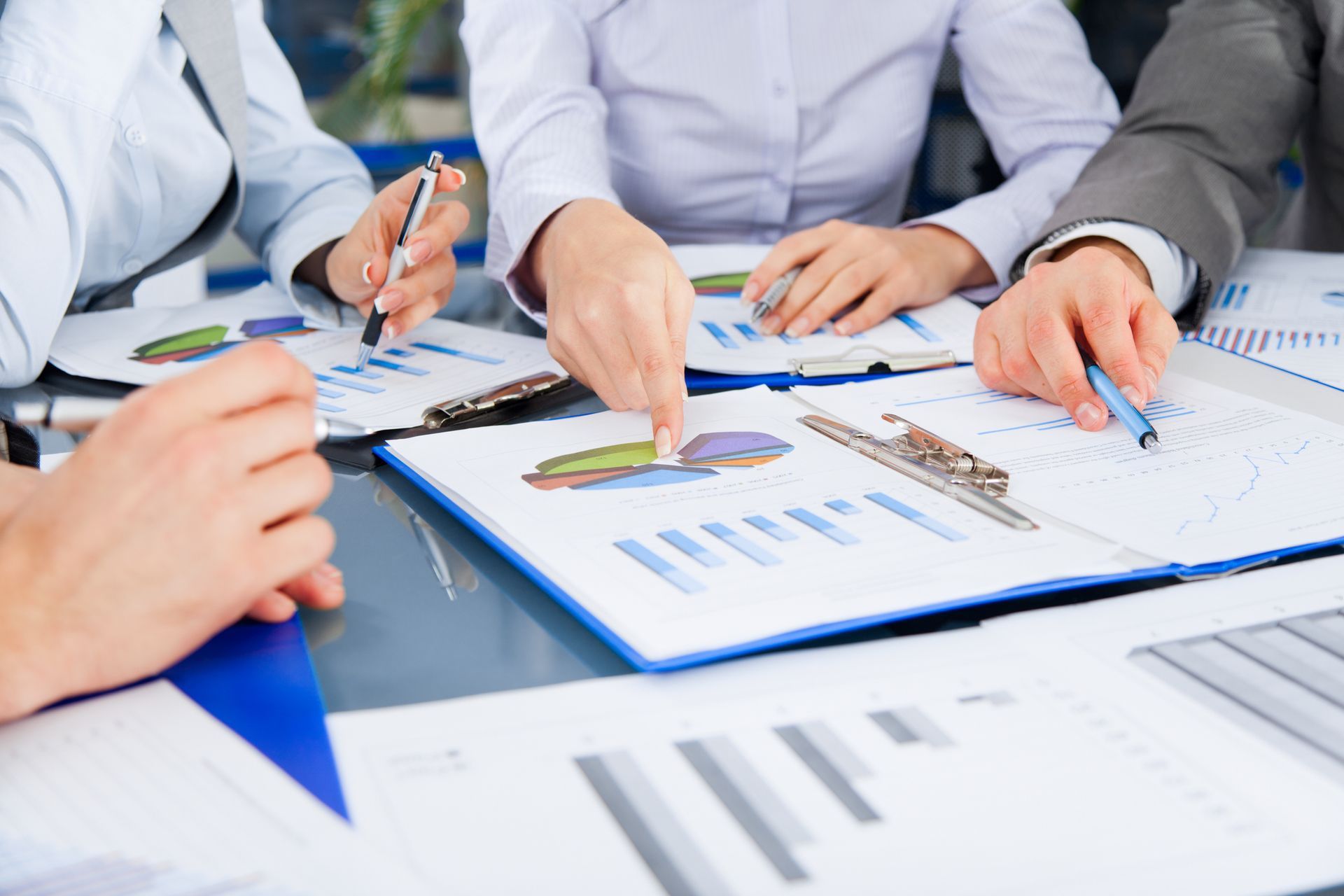 A group of people are sitting around a table looking at graphs.