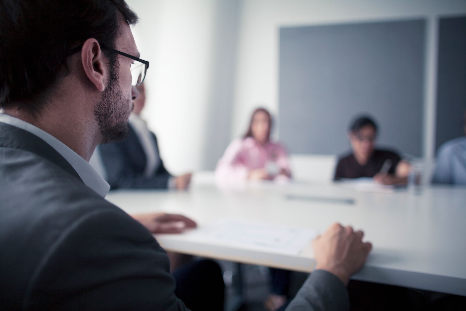 A man is sitting at a table in front of a group of people.