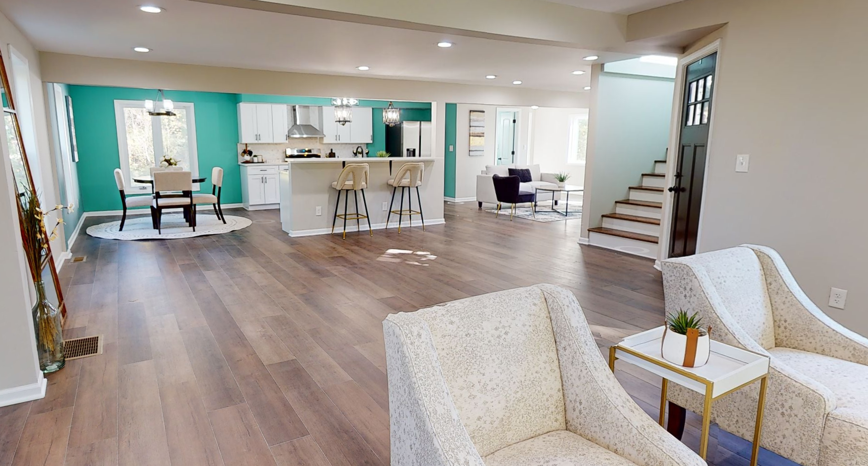 A living room with two chairs and a table in a house.