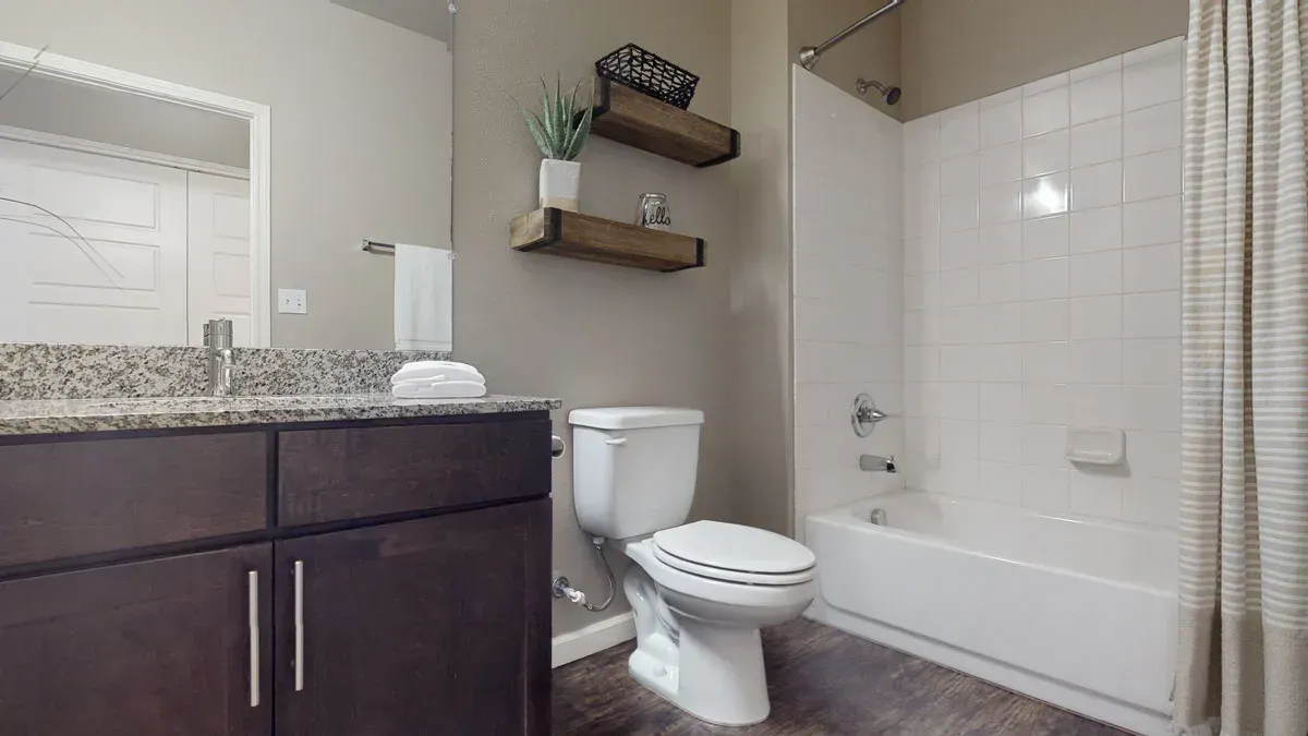 A bathroom with a toilet , sink , and bathtub.