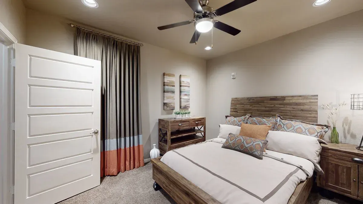 A bedroom with a bed and a ceiling fan.