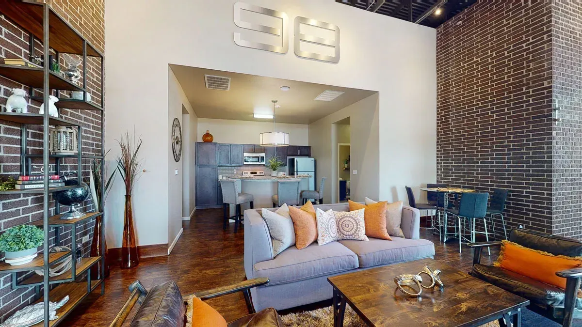 Clubhouse with a couch , table , chairs and a brick wall.