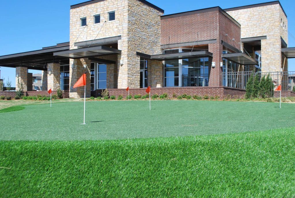 A large building with a golf course in front of it.