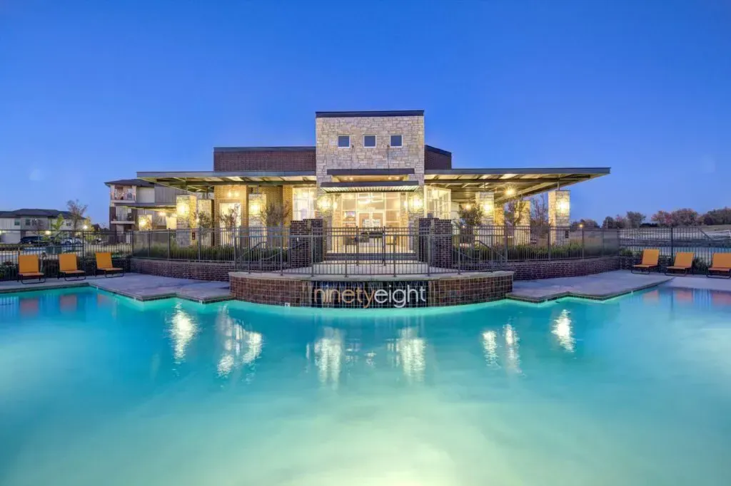 There is a large swimming pool in front of a building.