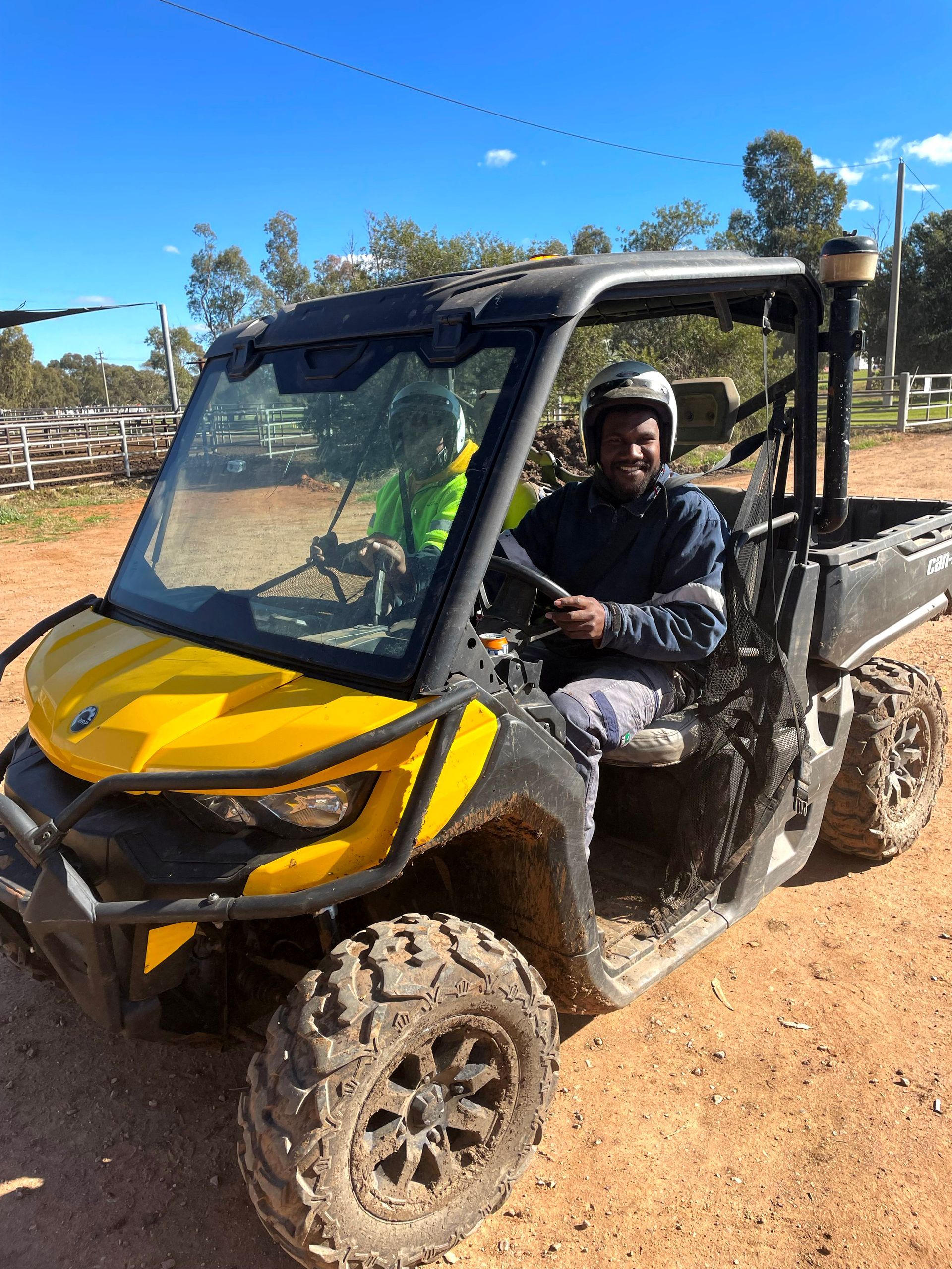 A man is sitting in a yellow atv on a dirt road.