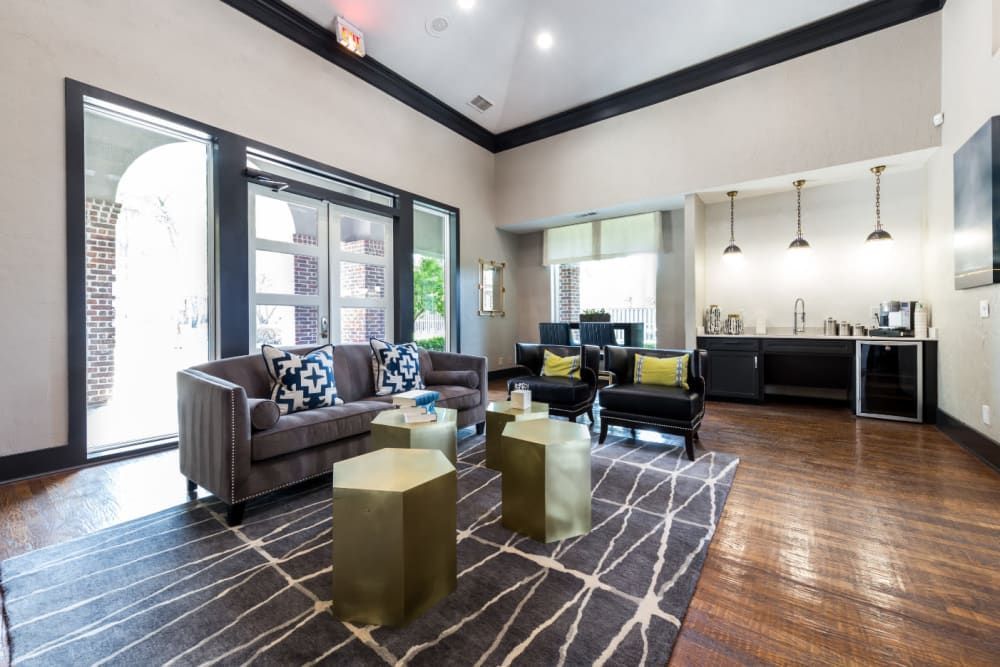 Clubhouse with a couch, chairs, tables, and a rug at Marquis at Legacy in Plano, TX.