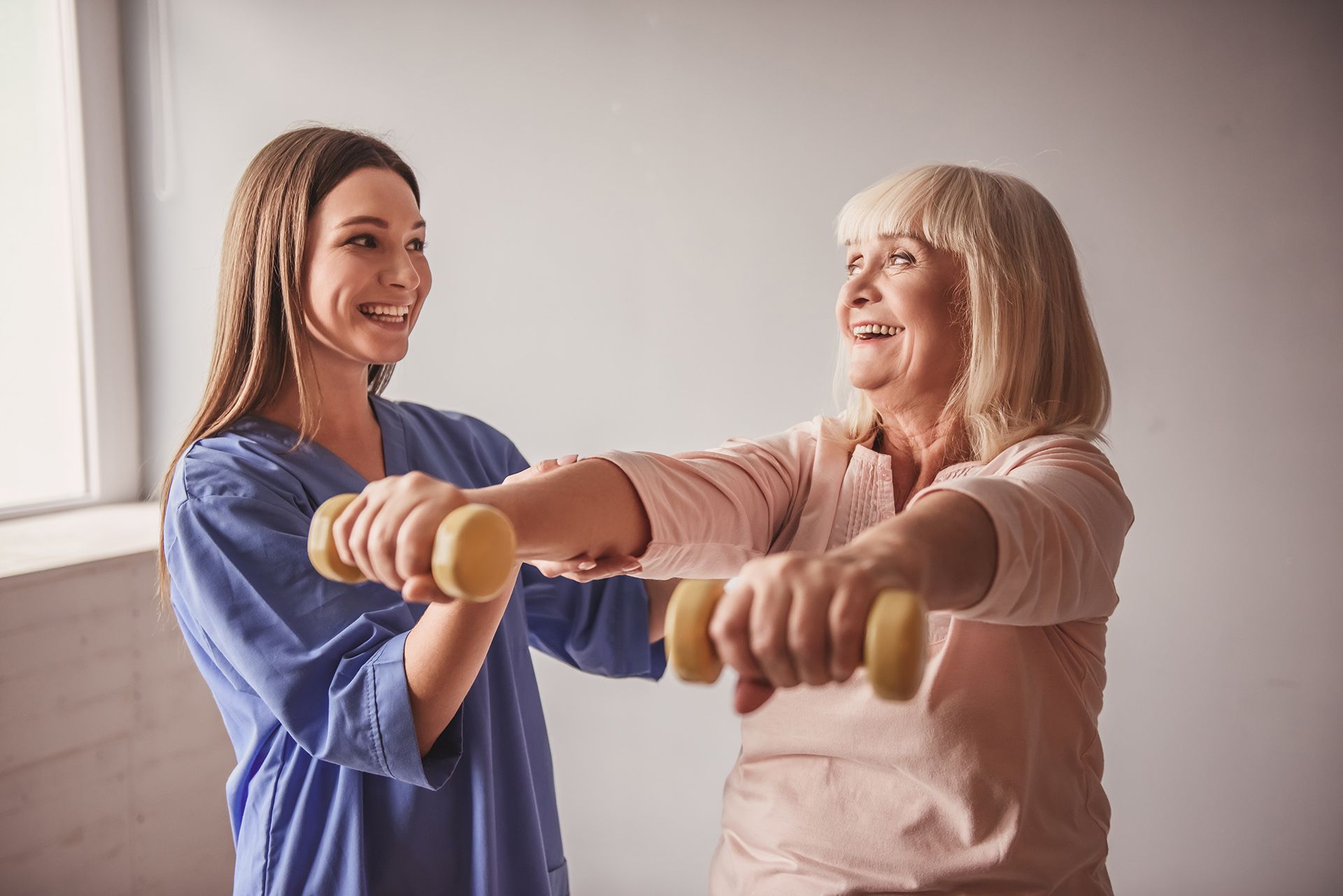 Helping an Elderly Woman Lift Dumbbells