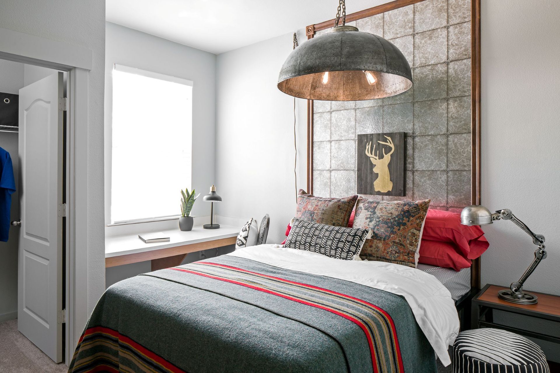 Fully furnished bedroom with large window and modern furniture at Hawks Ridge student apartments in Iowa City