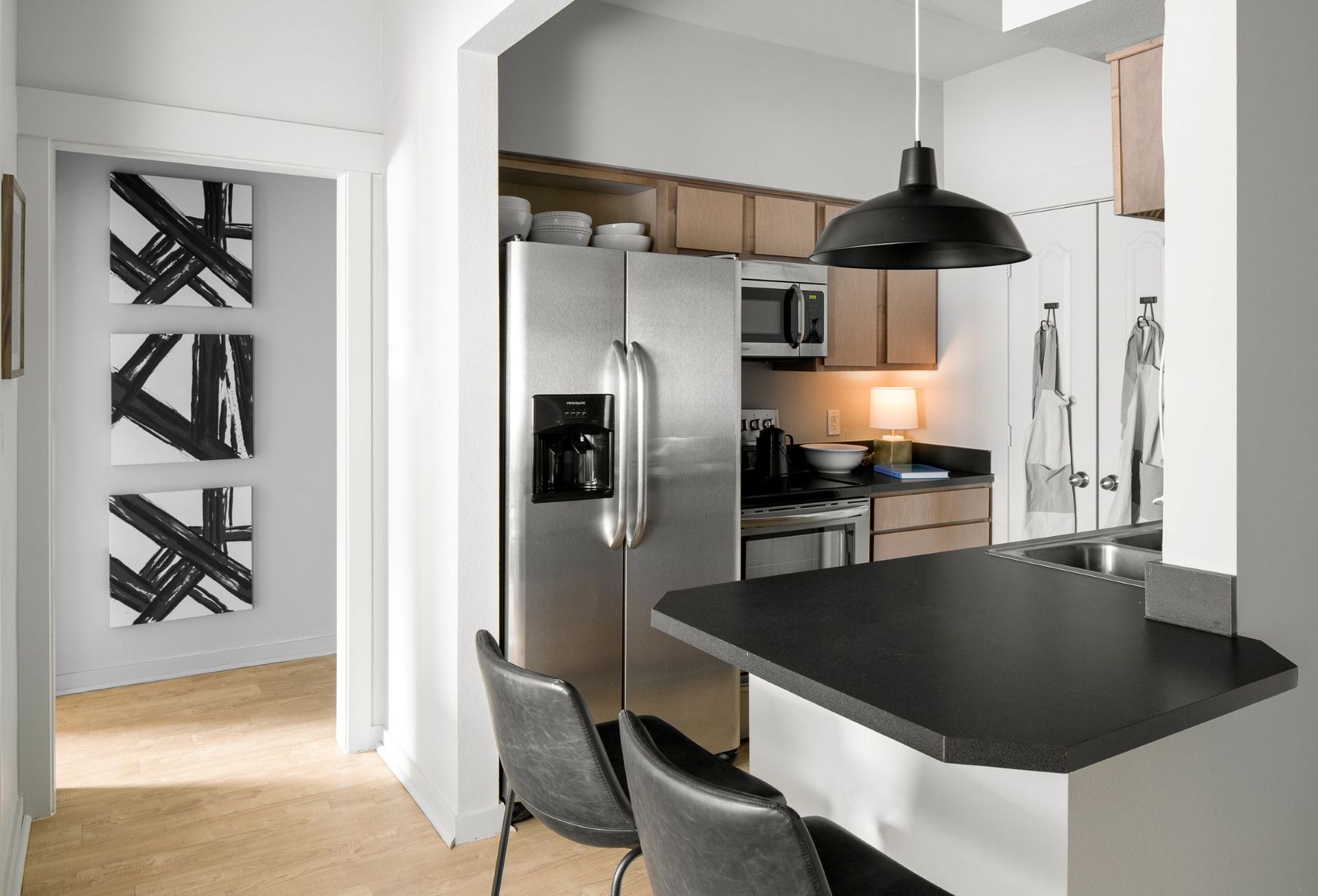 Updated kitchen with stainless steel appliances and hardwood-style flooring