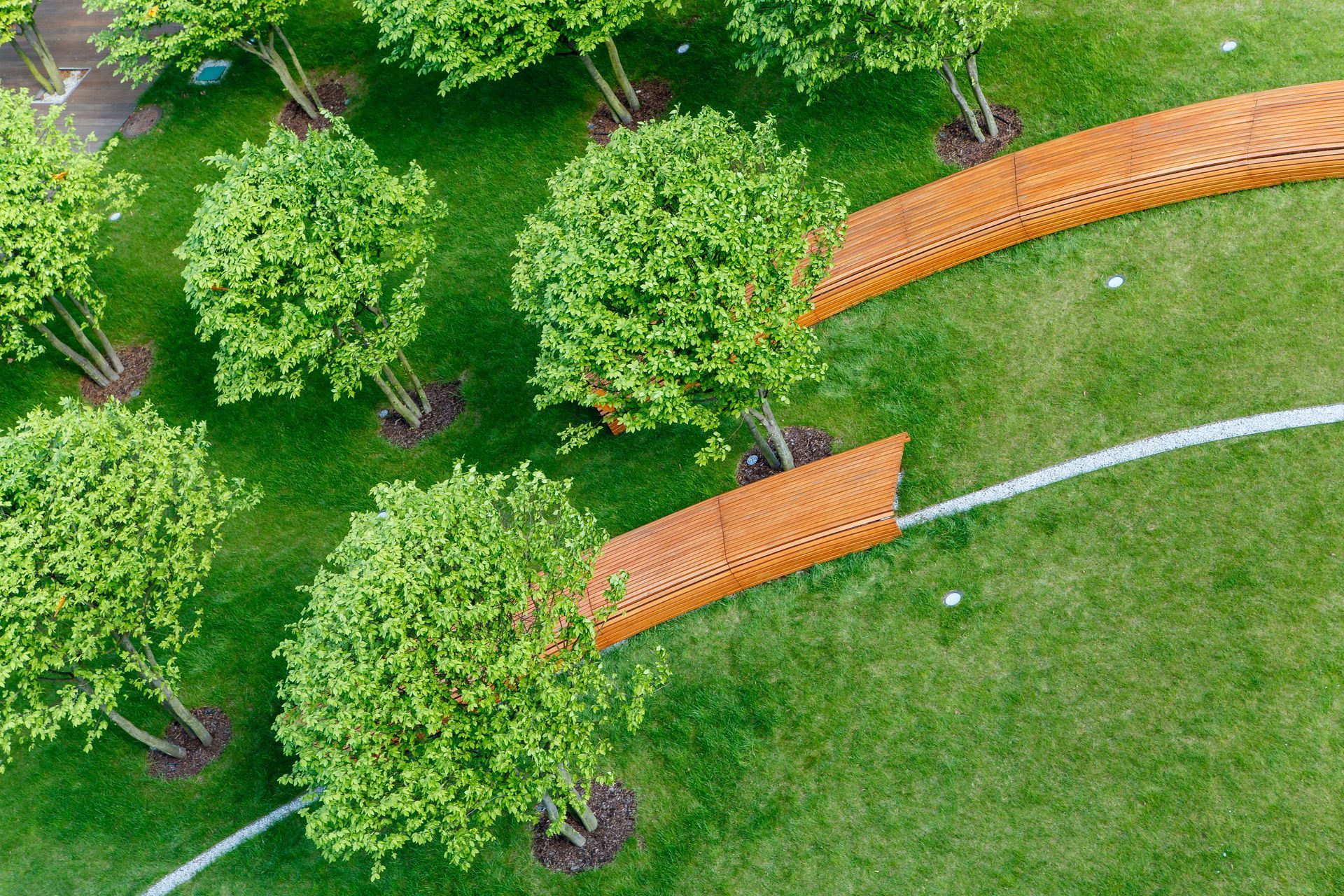 Aerial view of a green park with trees and curved wooden bridges. Aerial view of a green park with trees and curved wooden bridges.