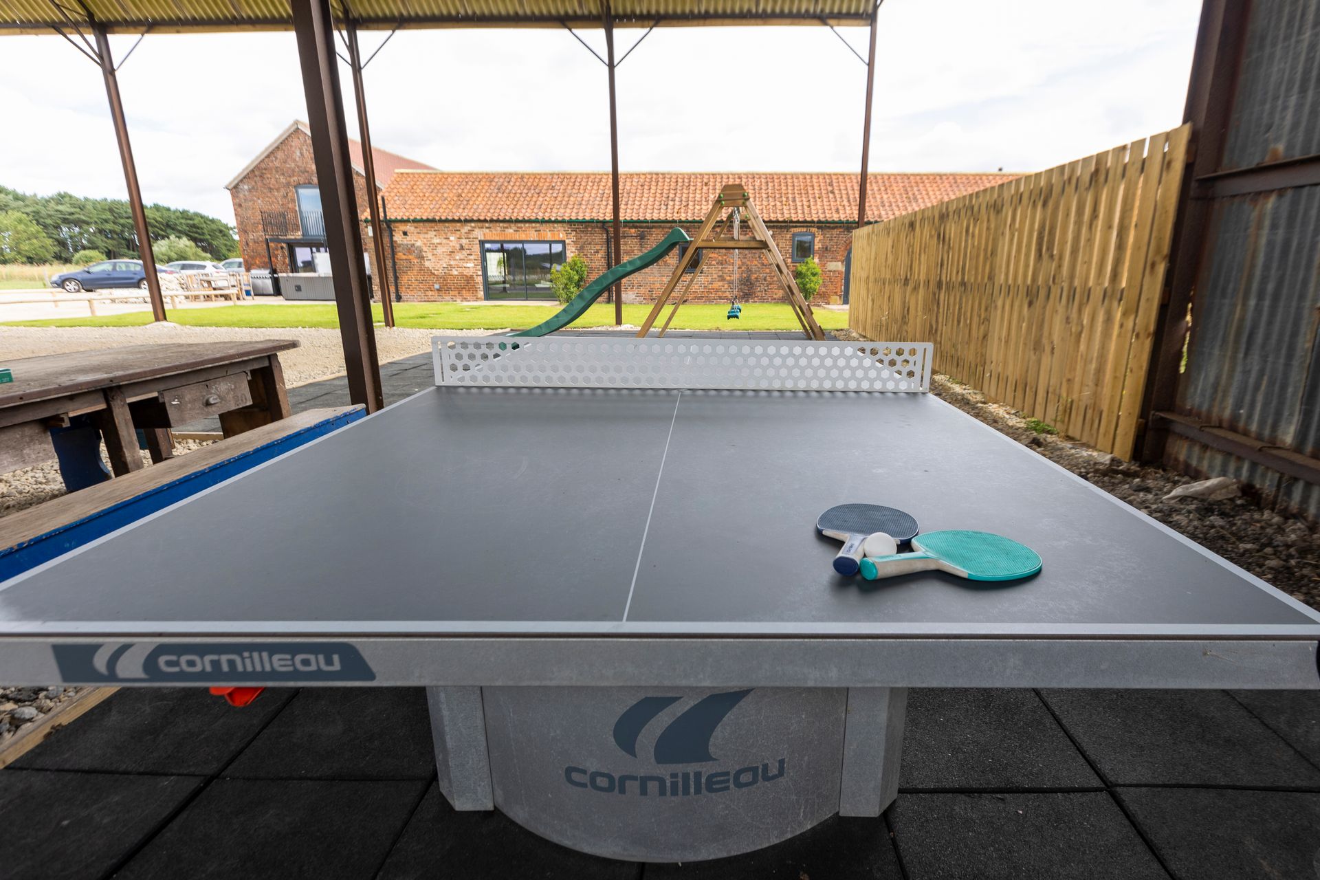 A large house with a patio and a dining room with tables and chairs.