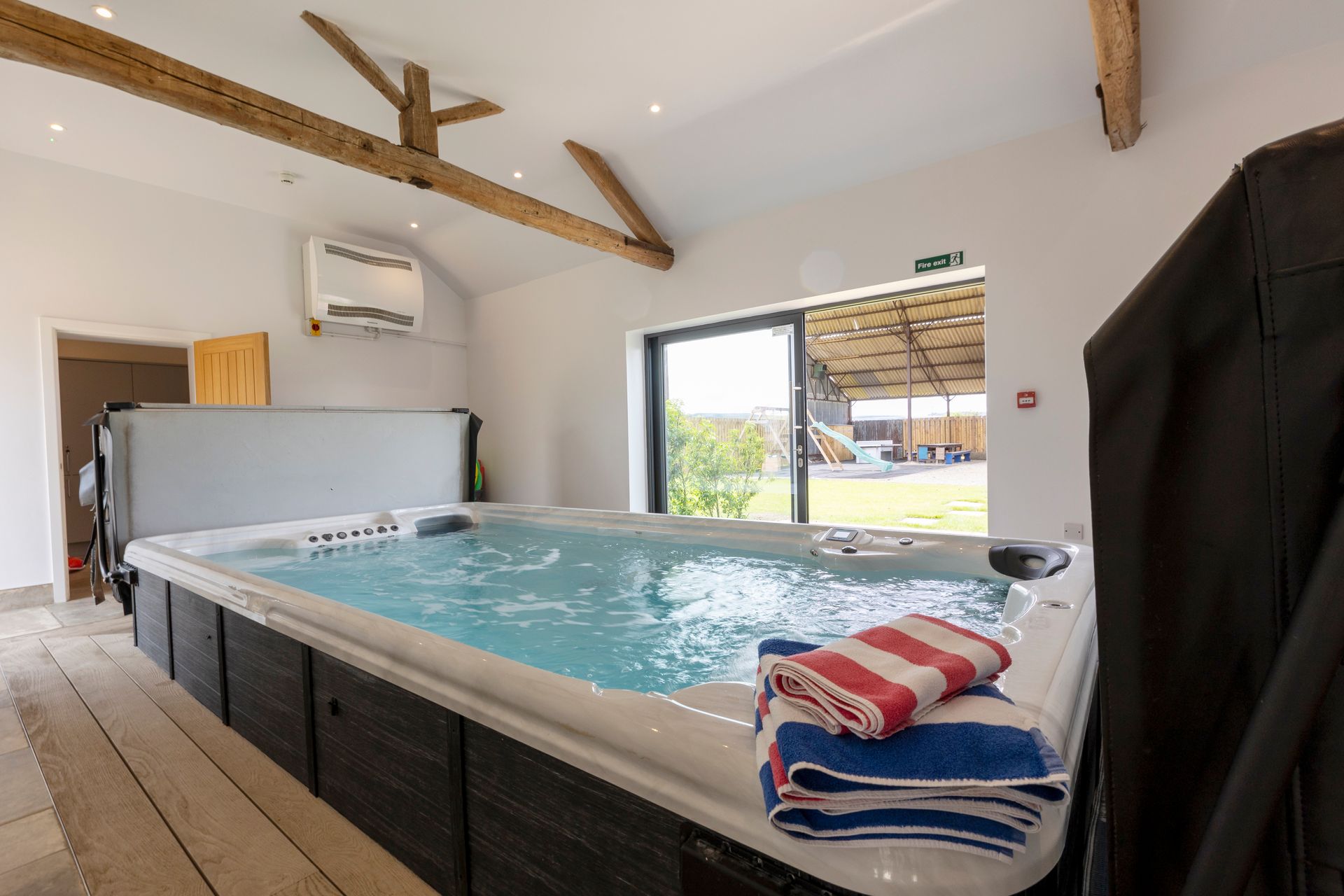 A large hot tub is sitting in a room next to a window.