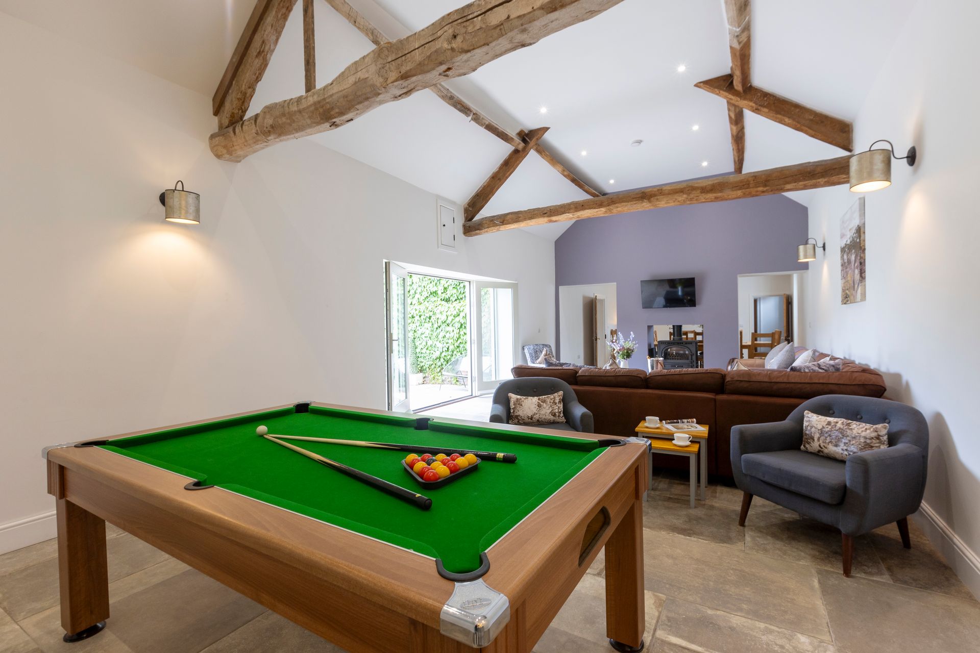 A dining room with a long wooden table and chairs.