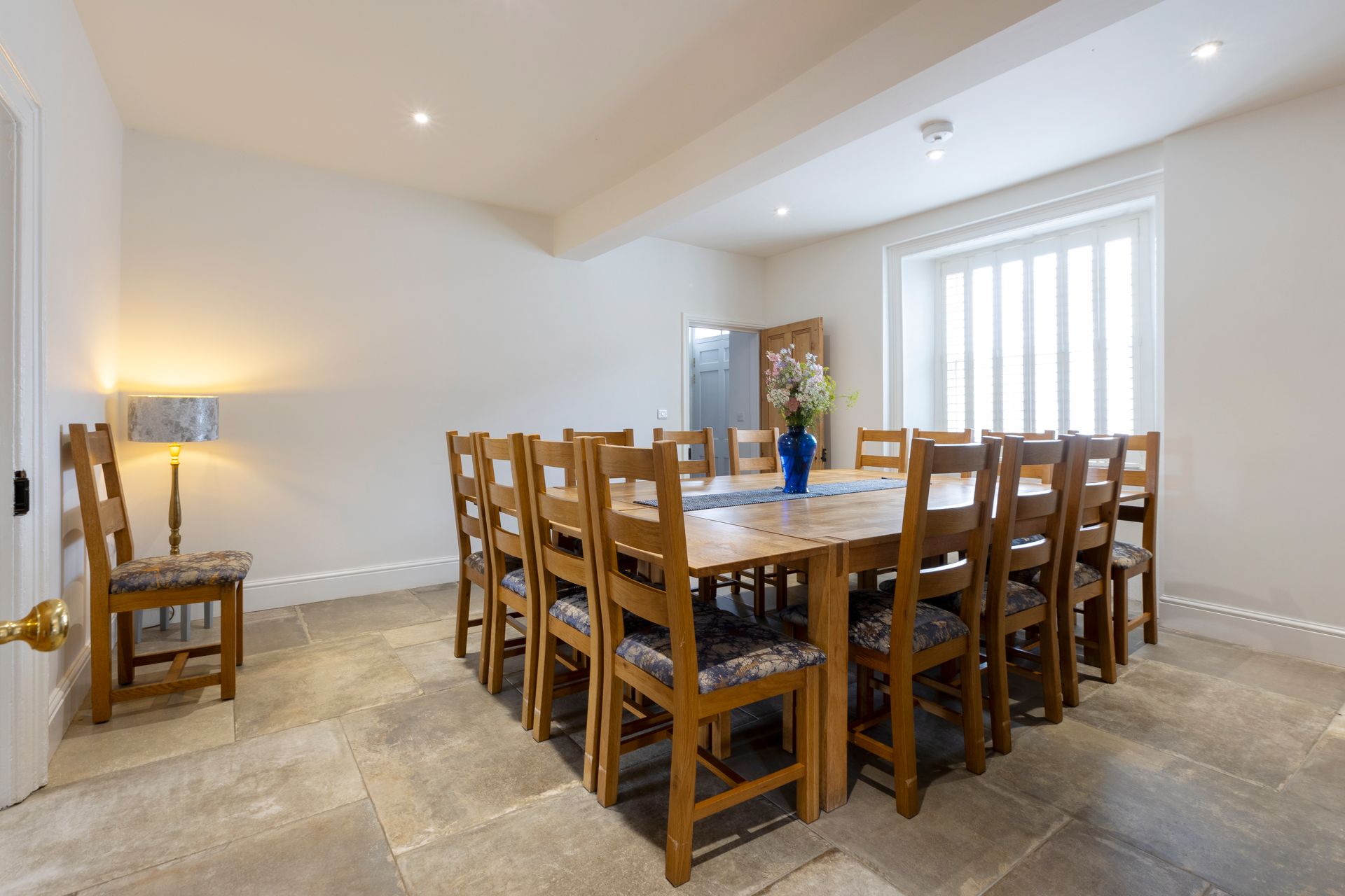 A dining room with a long wooden table and chairs.