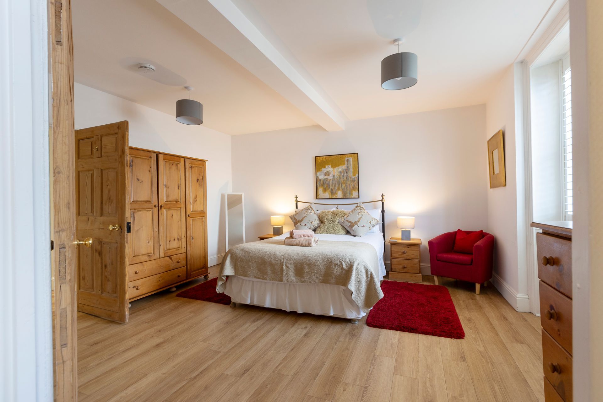 A bedroom with two beds and two lamps