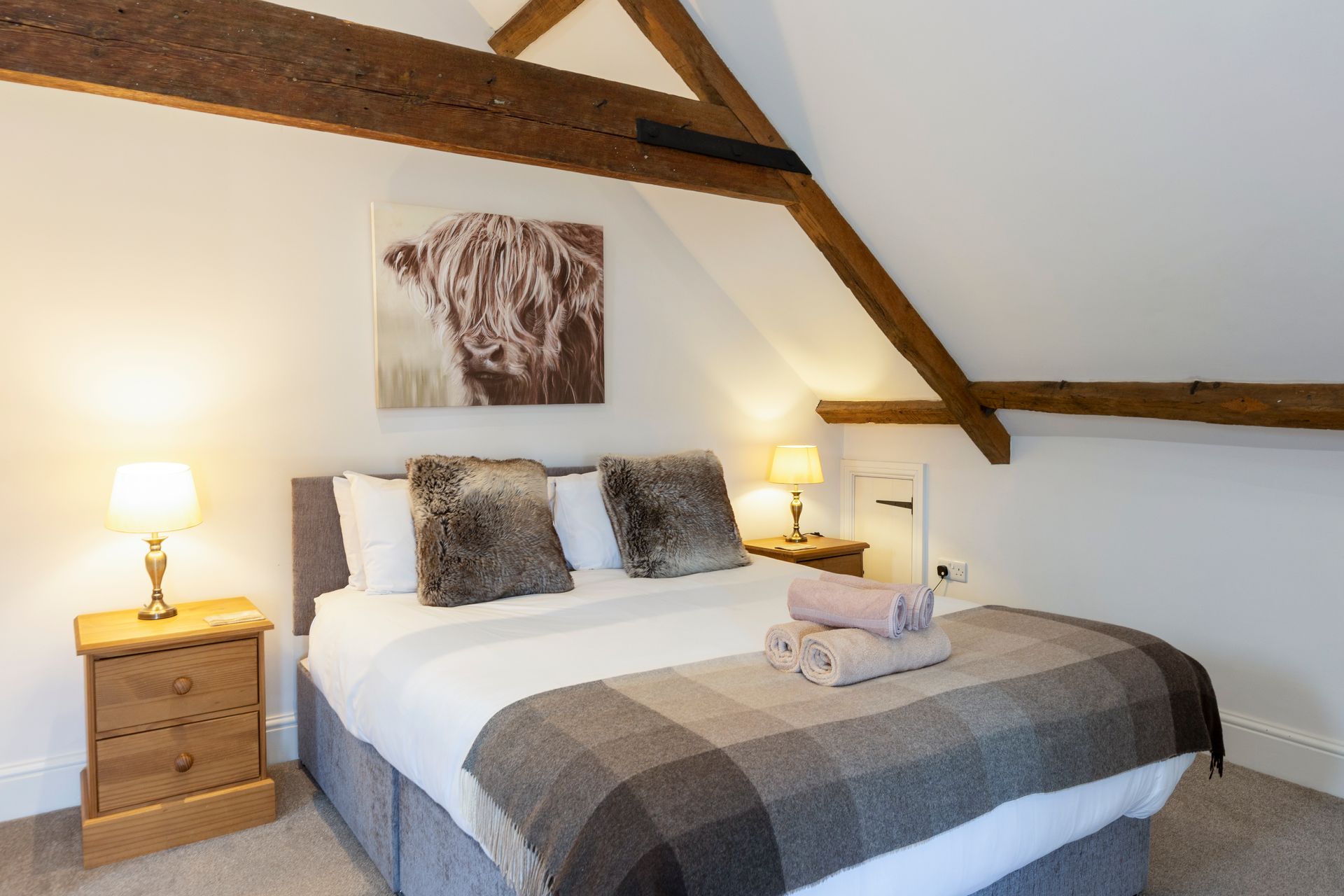 A bedroom with a king size bed and a picture on the wall above it.