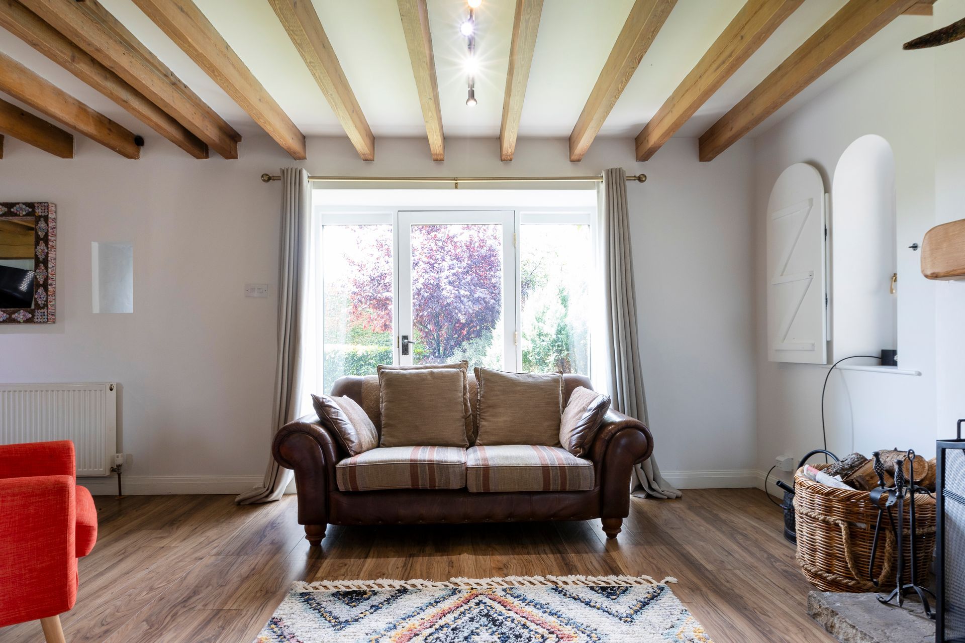 A bedroom with three beds and a large window.