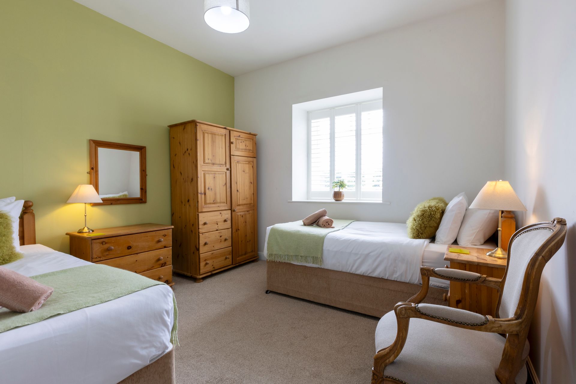 A bedroom with a king size bed , nightstand , chair and desk.
