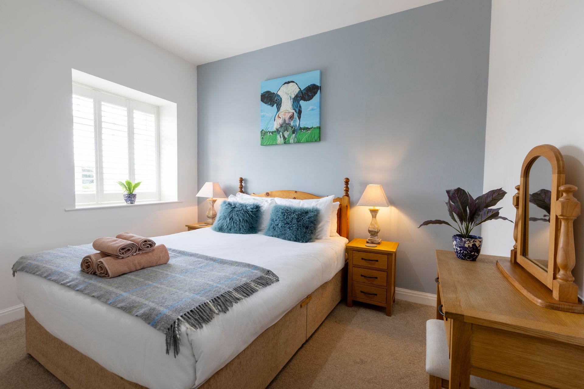 A bedroom with a large bed and a painting on the wall.