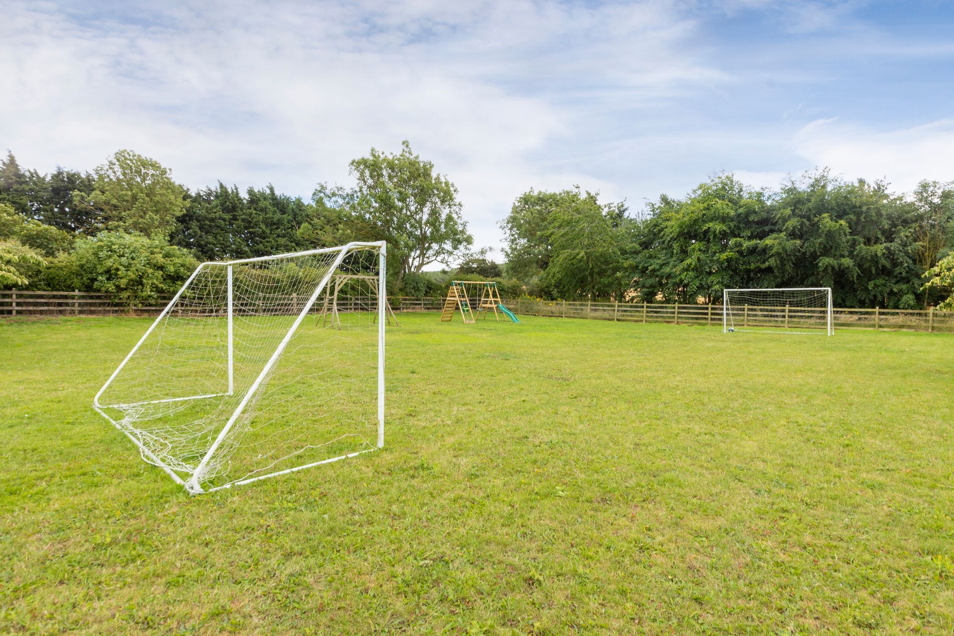A large house with a patio and a dining room with tables and chairs.