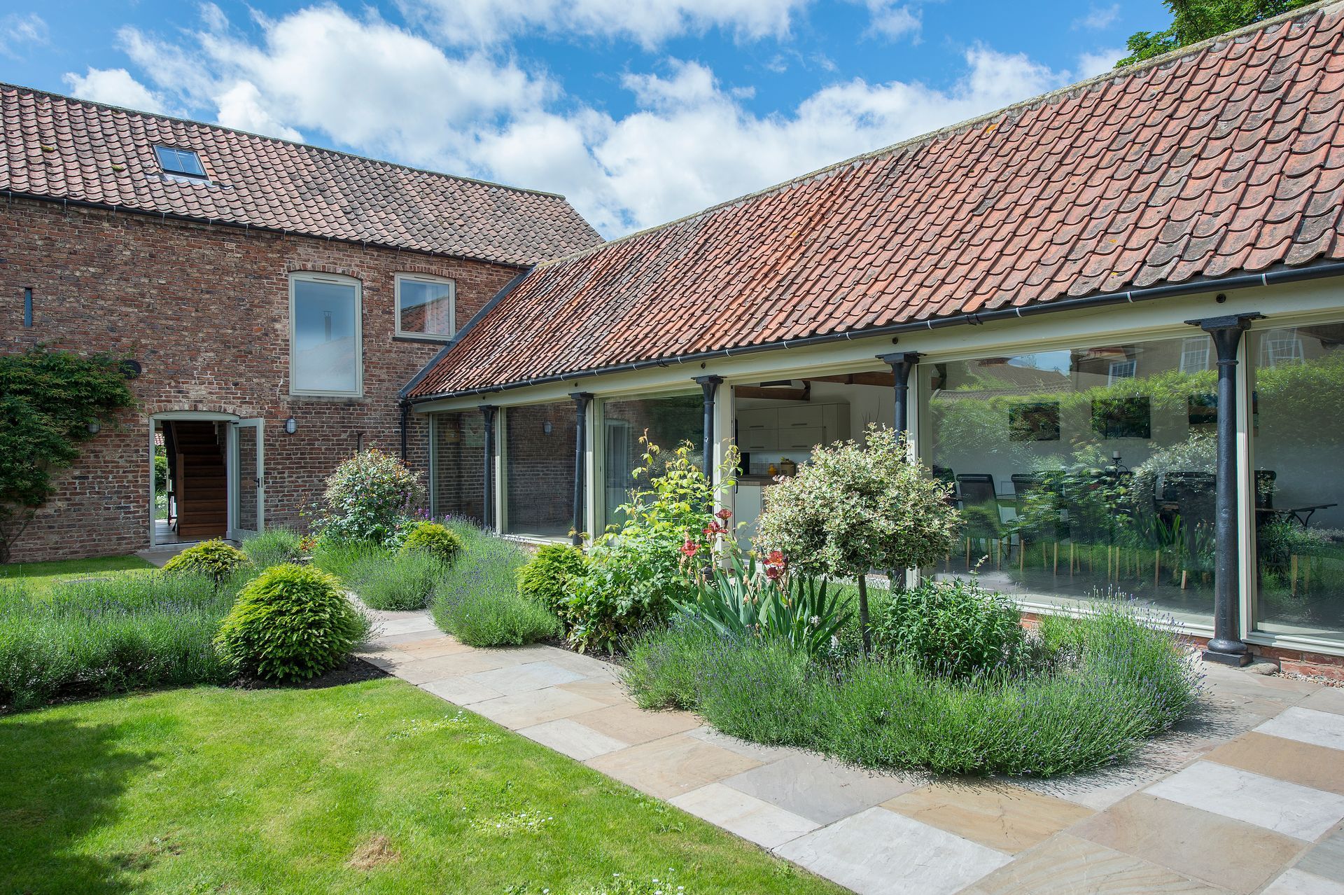 A large house with a patio and a dining room with tables and chairs.