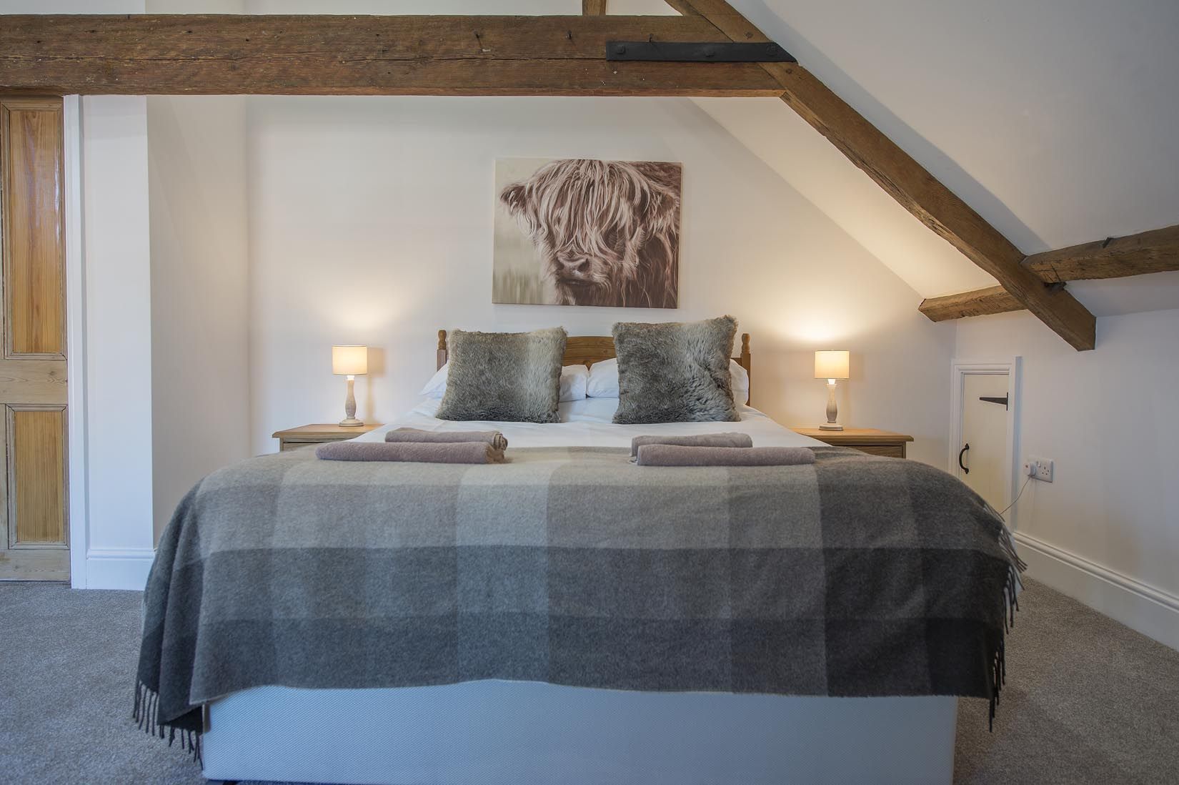 A bedroom with a king size bed and a picture on the wall above it.