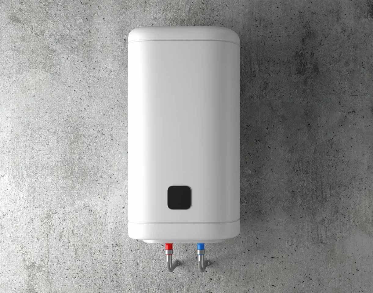 Chauffe-eau électrique blanc fixé sur un mur en béton gris, avec des tuyaux rouges et bleus visibles.