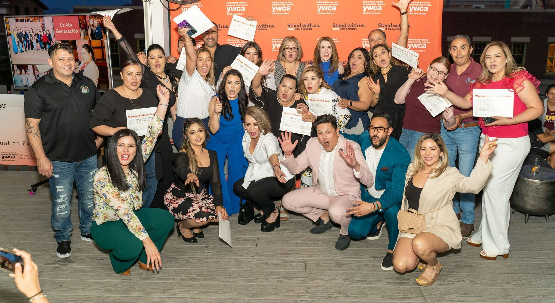 A group of people are posing for a picture while holding certificates.