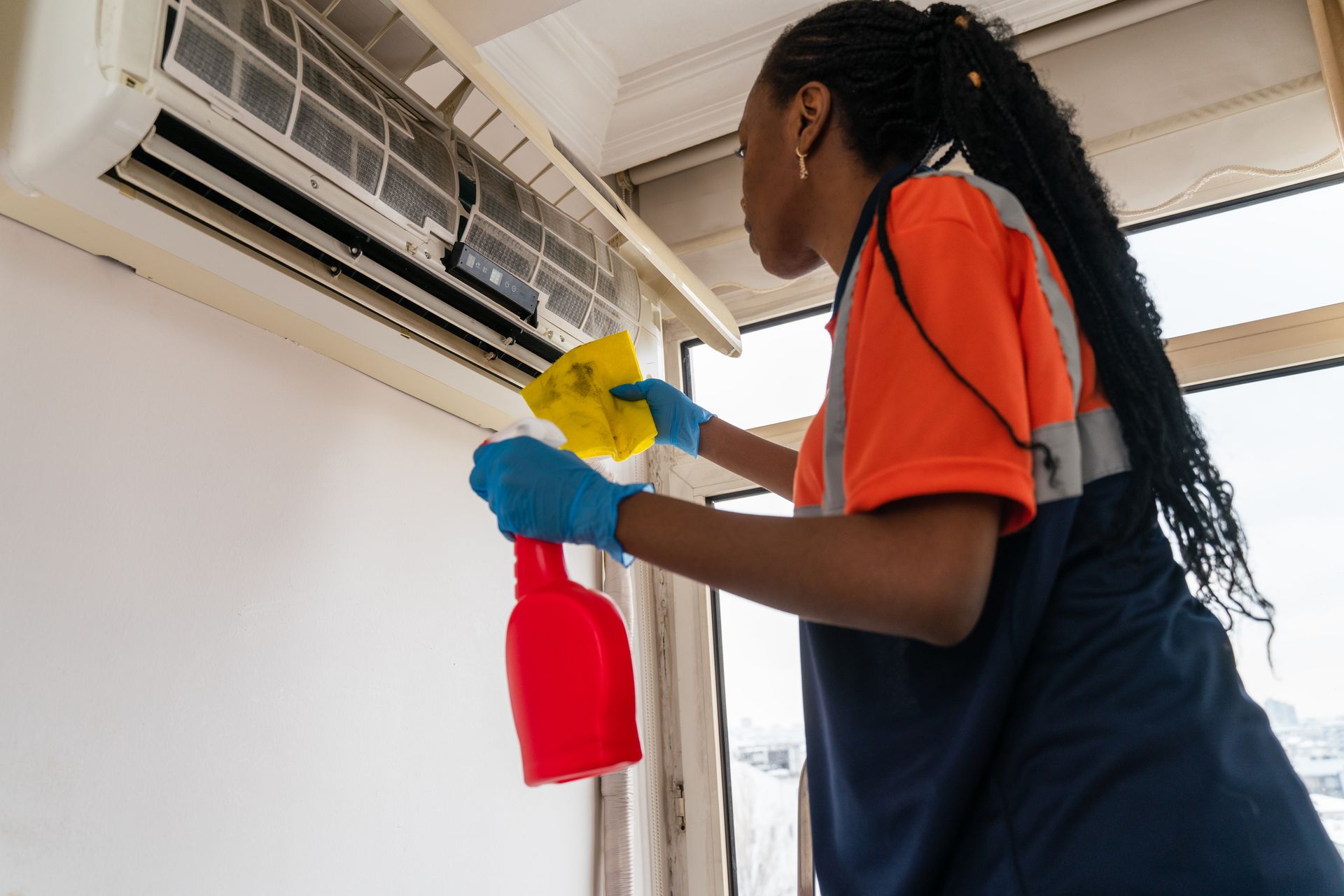 A Grant HVAC technician maintaining air conditioning unit.