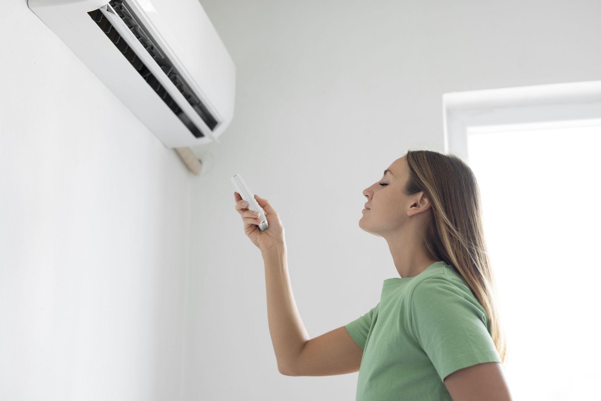 Homeowner adjusting a smart thermostat to control indoor humidity in a Mississippi home.