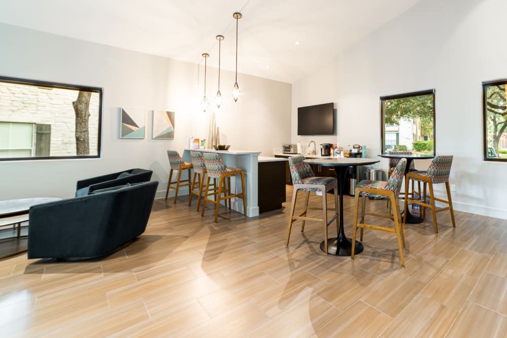a room with hardwood floors , tables and chairs at Marquis at Great Hills in Austin, TX.