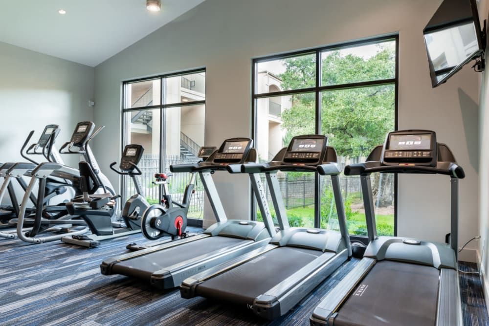 a gym with a lot of treadmills and exercise bikes at Marquis at Great Hills in Austin, TX.