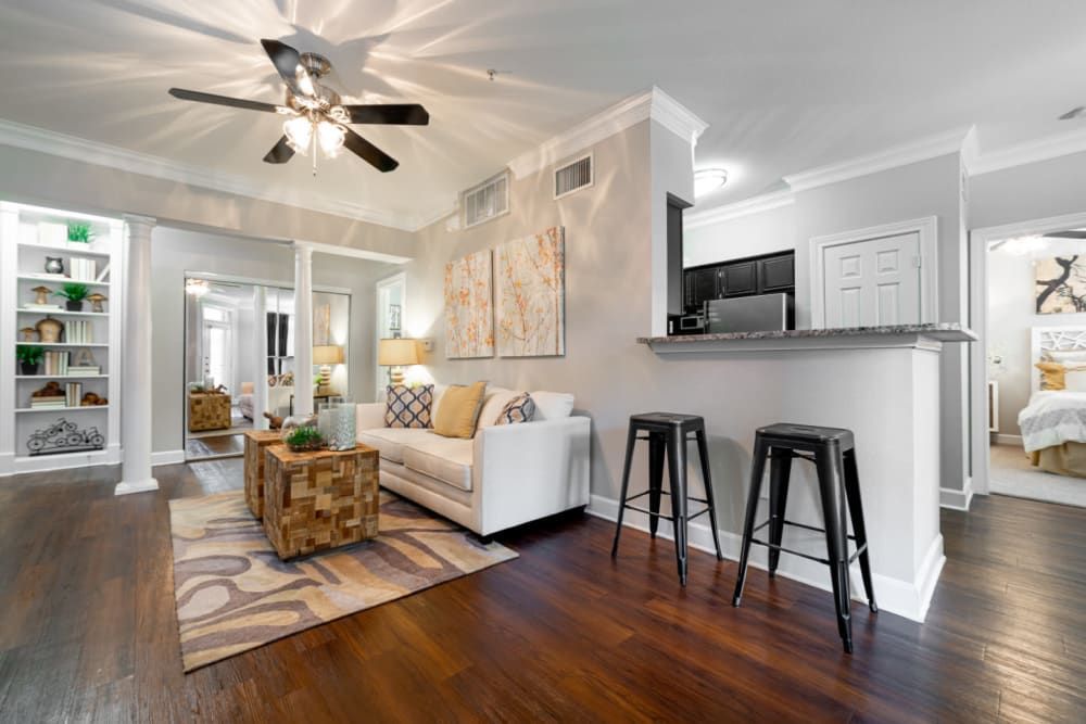 a living room with hardwood floors and a ceiling fan at Marquis at Great Hills in Austin, TX.
