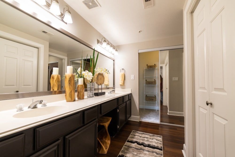 a bathroom with two sinks and a large mirror at Marquis at Great Hills in Austin, TX.