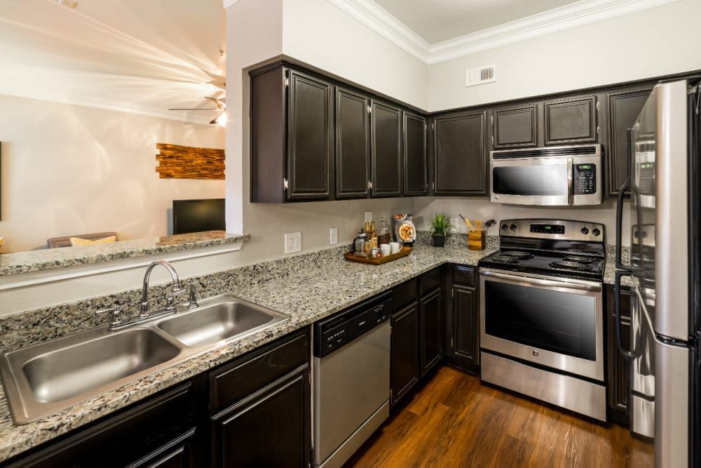 a kitchen with stainless steel appliances and granite counter tops at Marquis at Great Hills in Austin, TX.