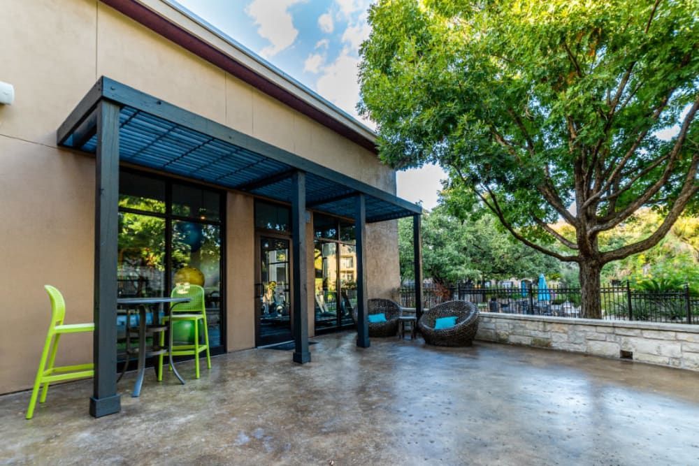 a large patio area with tables and chairs under a canopy at Marquis at Great Hills in Austin, TX.