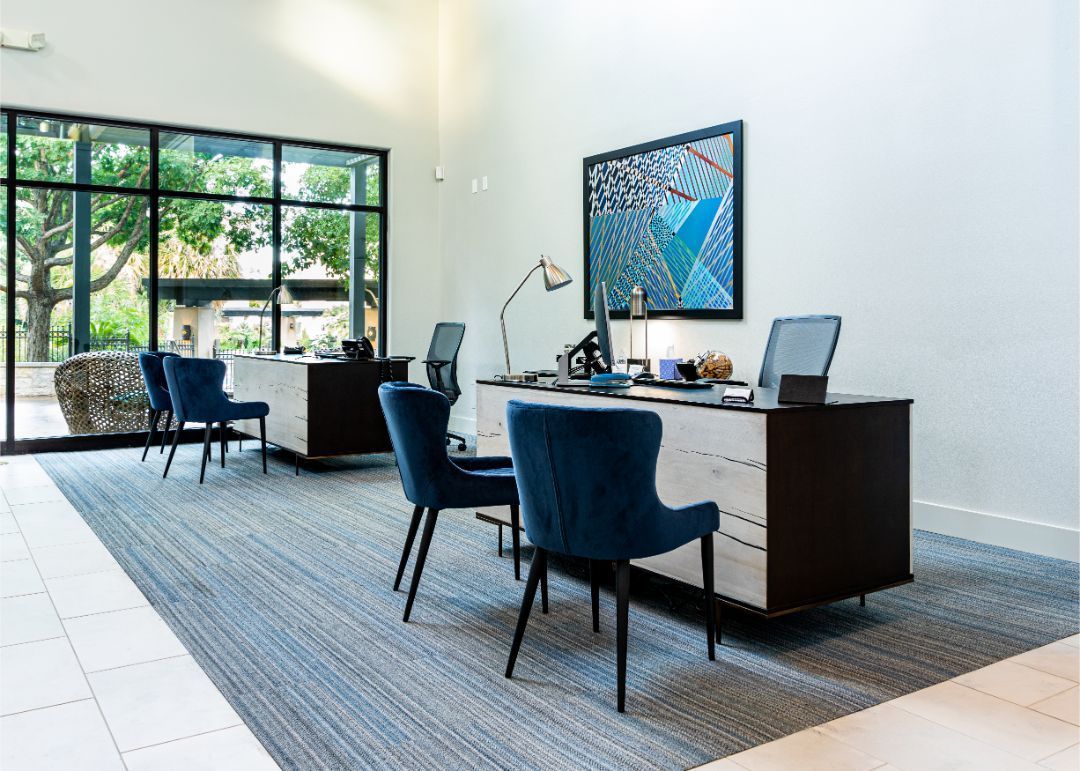a lobby with a desk, chairs, and a large window at Marquis at Great Hills in Austin, TX.