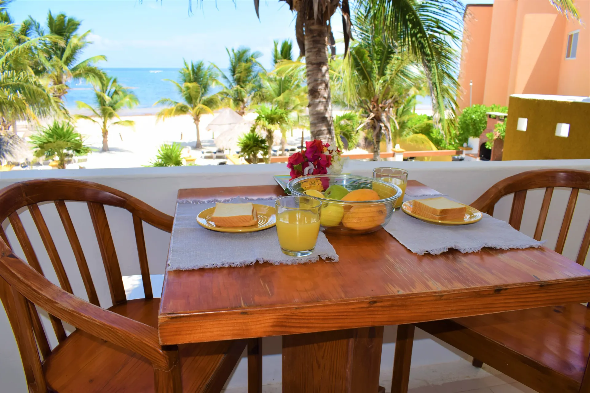 Mesa de desayuno situada en el balcón con vistas a la playa y al océano.