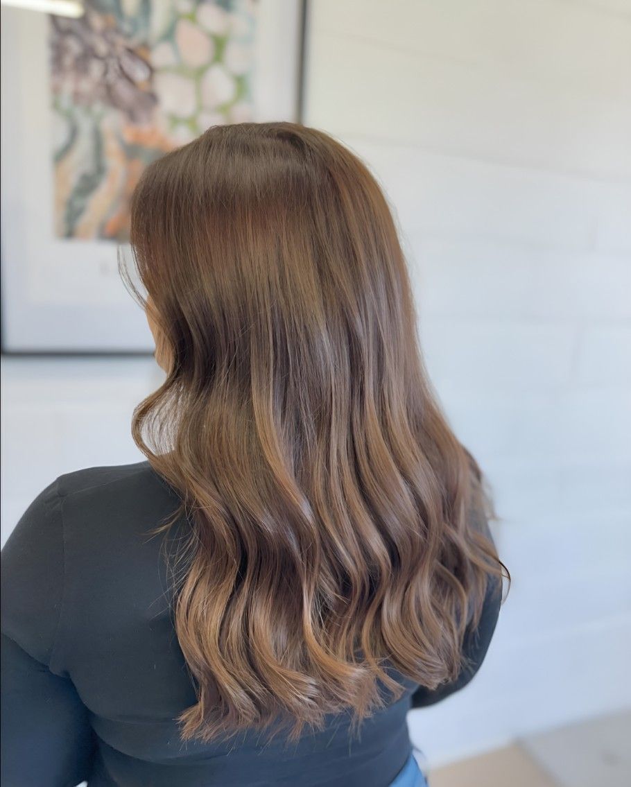 A Woman With Long Brown Hair is Wearing a Black Shirt — Atelier Of Hair in Grafton, NSW