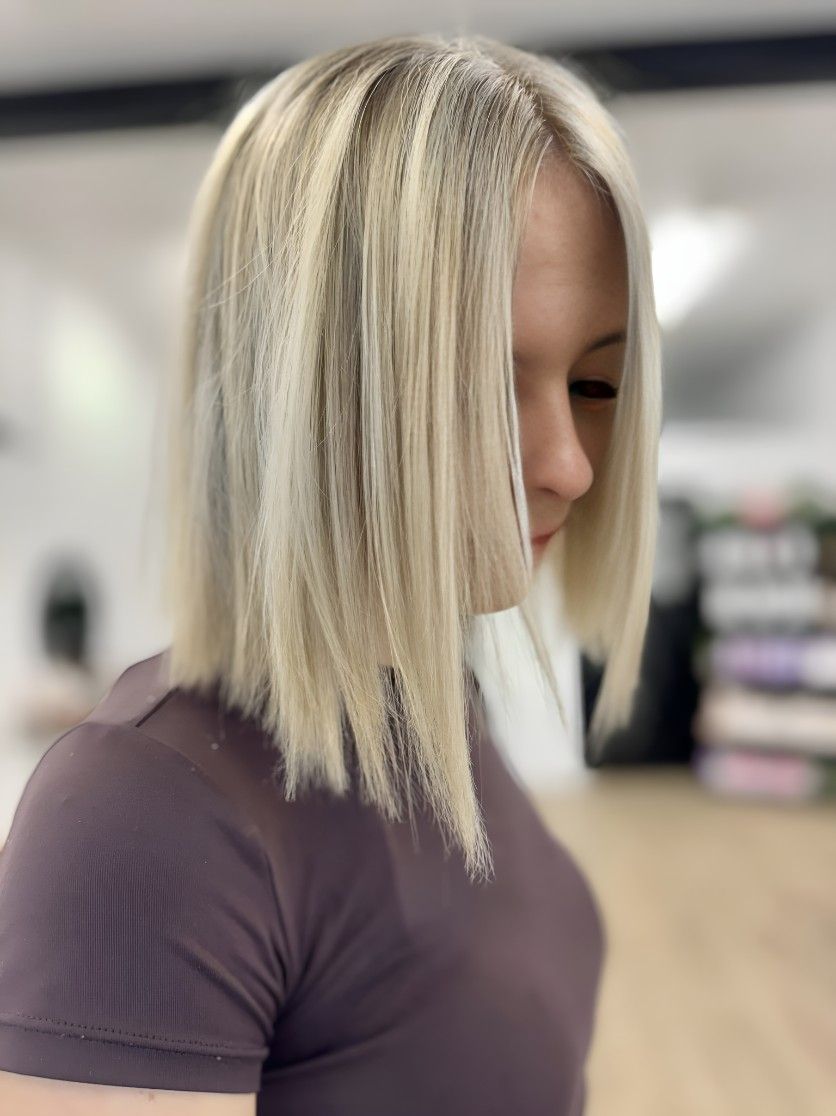 A Woman With Blonde Hair is Wearing a Purple Shirt — Atelier Of Hair in Grafton, NSW