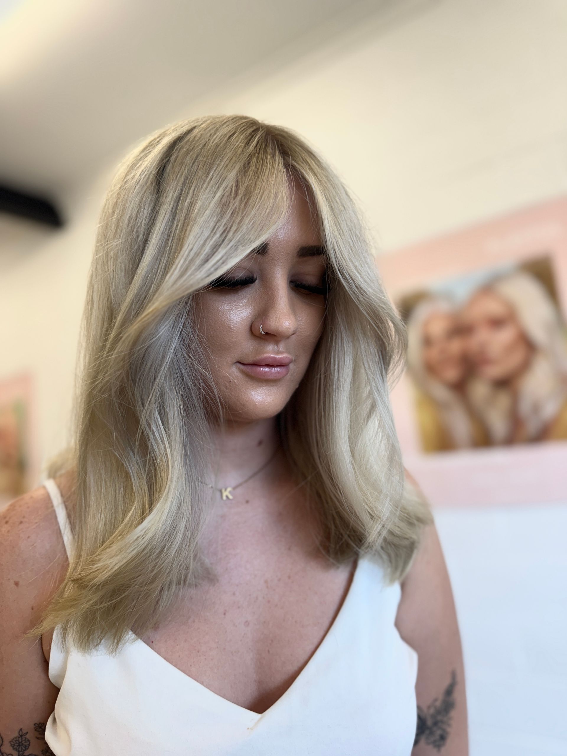 A Woman With Long Blonde Hair looking down — Atelier Of Hair in Grafton, NSW
