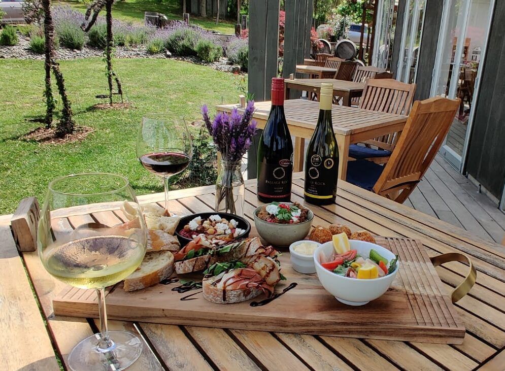 Tasting platter spread and wine bottles and Passage Rock Winery