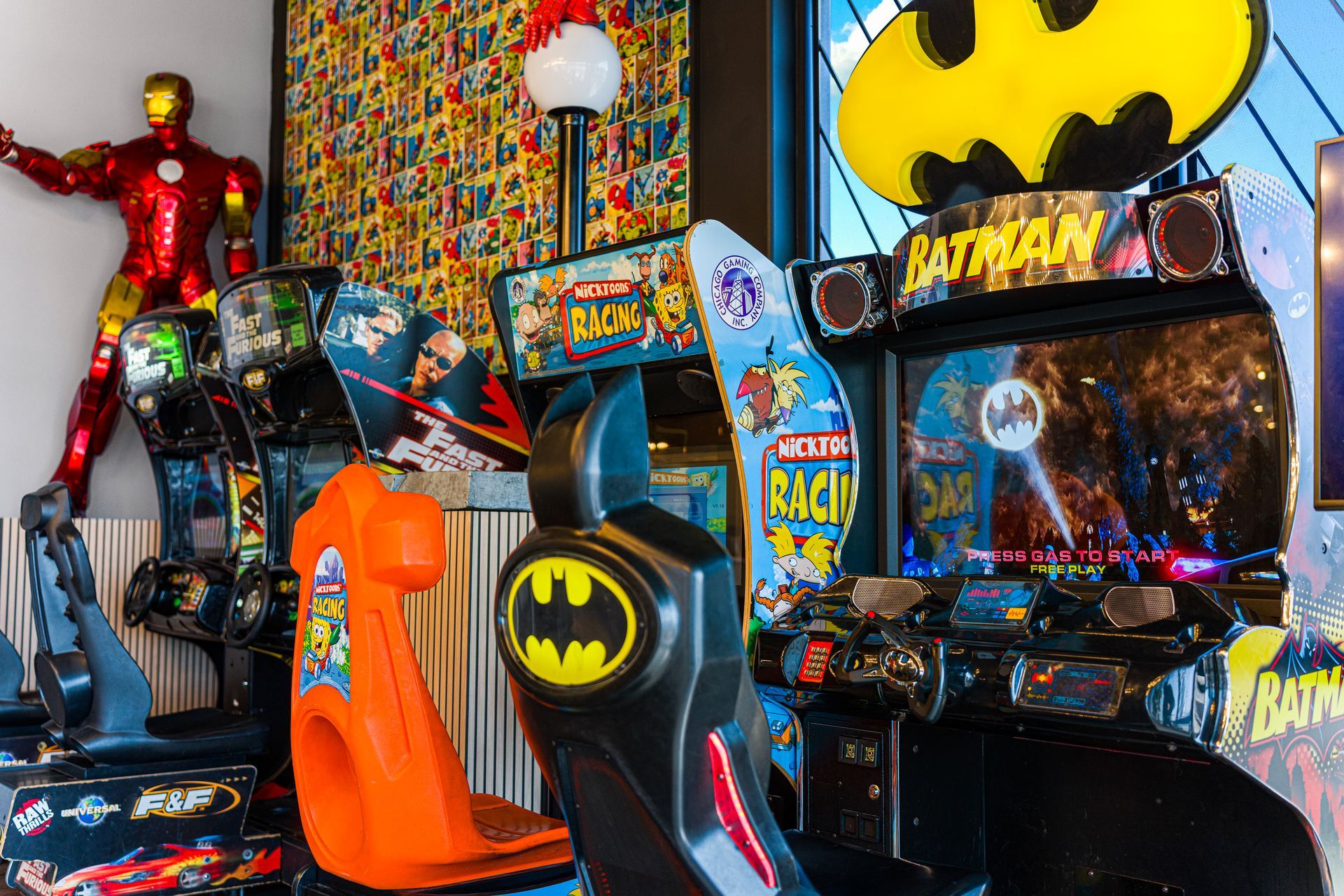 Batman arcade games and superhero displays in a bright, colorful game room